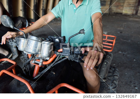 A skilled rider navigating an ATV in an expansive and abandoned warehouse setting 132649167