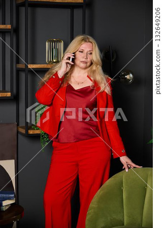energetic marketing specialist in bold red attire evaluates campaign results during urgent call energetic marketing specialist in bold red attire evaluates campaign results during urgent call 132649206
