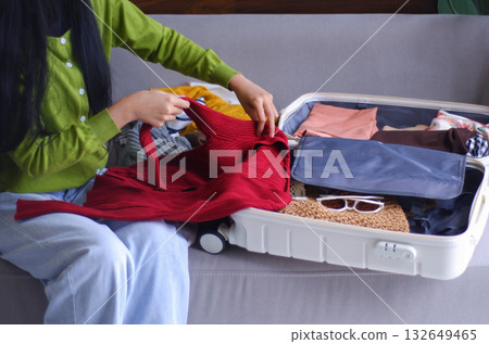 Young women packing luggage for holiday trip. Young women packing luggage for holiday trip. 132649465
