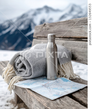 wool blanket, metal thermos and ski slope map on a wooden bench, snowy mountains in background, adventure vibe 132649553