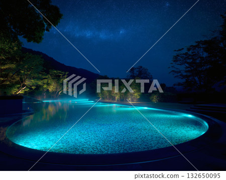 A fantastical illuminated pool shining under the starry sky 132650095