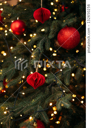 a festive Christmas tree decorated with red ornaments, glowing fairy lights, and natural green pine needles a festive Christmas tree decorated with red ornaments, glowing fairy lights, and natural green pine needles 132650256