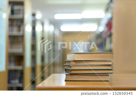 Book stack in the library and blurred bookshelf background for education 132650345