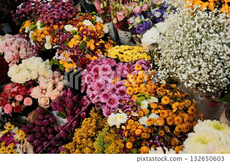Rich composition of colorful flowers and bouquets with roses, daisies, and chrysanthemums on street market Rich composition of colorful flowers and bouquets with roses, daisies, and chrysanthemums on street market 132650603