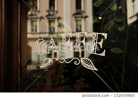 Elegant Caffe sign on a glass window with plant reflection and soft daylight Elegant Caffe sign on a glass window with plant reflection and soft daylight 132650665