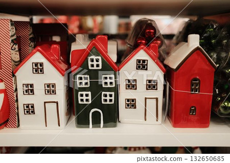Cute ceramic decorative houses in red, green, and white Christmas colors displayed on shelf Cute ceramic decorative houses in red, green, and white Christmas colors displayed on shelf 132650685