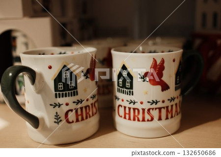 Detailed view of a white Christmas mug decorated with a red bird and green house illustration Detailed view of a white Christmas mug decorated with a red bird and green house illustration 132650686