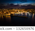 Iconic view of the illuminated historic center, harbor, and castle of Monopoli, Italy, at night 132650976
