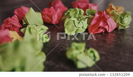 Colorful paper balls playfully dot the wood. 132651204