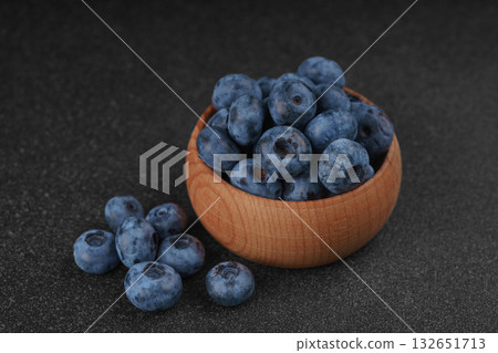 Fresh ripe blueberries in wooden bowl on dark gray stone background closeup macro healthy food 132651713