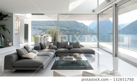 Modern living room with large windows showcasing breathtaking mountain lake view, featuring sleek furniture, minimalist decor, and a bright, airy atmosphere for contemporary lifestyle 132651798