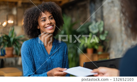 Smiling Woman Receives Envelope in Modern Office Setting 132652103
