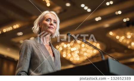 Confident Woman Delivering Keynote Speech in Luxury Hotel Ballroom 132652389