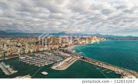 Aerial drone view of Alicante marina, Santa Barbara Castle, and Mediterranean coast under dramatic cloudy sky 132653267
