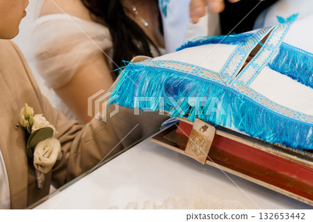 Bride and Groom at Wedding Ceremony Holding Ornate Blue and White Torah Scroll with Fringe Trim Bride and Groom at Wedding Ceremony Holding Ornate Blue and White Torah Scroll with Fringe Trim 132653442