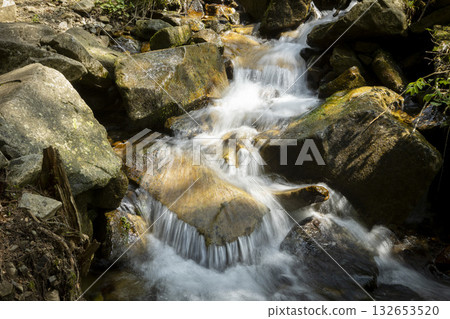 Water stream searching the path between the stones 132653520