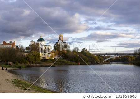 An evening view of a church on the riverbank. Autumnal cloudy weather, sunny. 132653606
