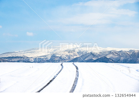 冬日北海道，積雪覆蓋的道路結冰，藍天白雲映襯著迷人的景色。 132654944