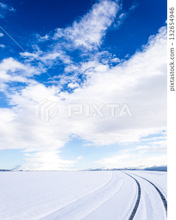 冬日北海道，積雪覆蓋的道路結冰，藍天白雲映襯著迷人的景色。 132654946
