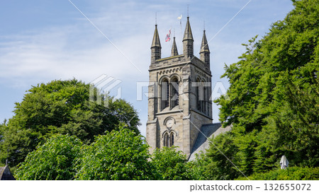 All Saints  Church rising over green trees in Helmsley, North York Moors National Park 132655072