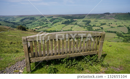 Empty wooden bench overlooking scenic green valley in North York Moors National Park 132655104