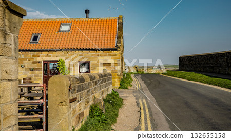 Stone cottage bordering road in Whitby, North York Moors National Park Stone cottage bordering road in Whitby, North York Moors National Park 132655158