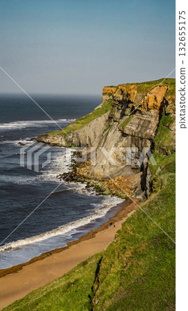 Scenic view of Whitby cliffs and beach meeting North Sea in North York Moors National Park Scenic view of Whitby cliffs and beach meeting North Sea in North York Moors National Park 132655175