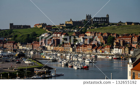 Whitby harbor with boats and Whitby Abbey dominating the skyline in North York Moors National Park 132655192