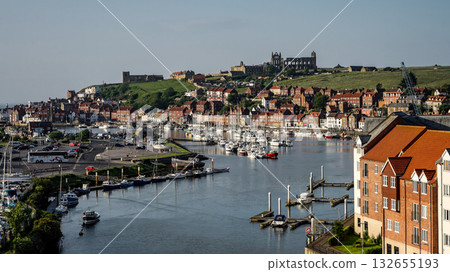 Whitby harbor with boats and Whitby Abbey dominating the skyline in North York Moors National Park 132655193