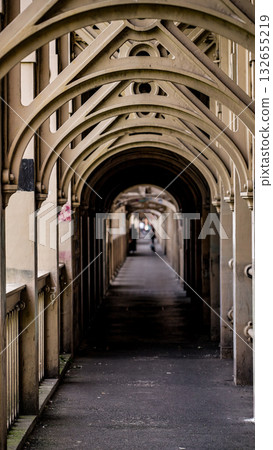 Covered walkway creating vanishing point under Tyne Bridge in Newcastle, UK 132655219