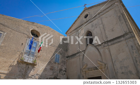 Church of Santa Maria della Neve rising in Tropea, Calabria, showcasing Italian and European flags Church of Santa Maria della Neve rising in Tropea, Calabria, showcasing Italian and European flags 132655303