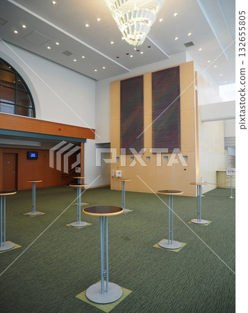 Modern hall lobby: green carpet and round high tables Modern hall lobby: green carpet and round high tables 132655805