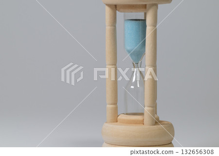 A wooden-framed hourglass bathed in soft light A wooden-framed hourglass bathed in soft light 132656308