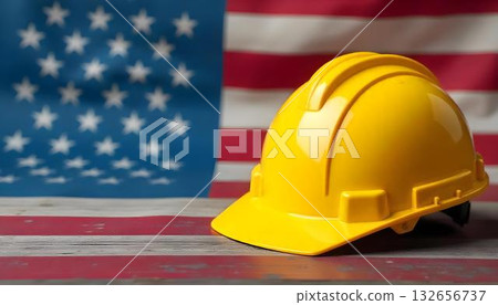 A construction helmet sits on a table with an American flag, highlighting Labor Day and the importance of various professions 132656737