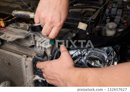 Careful precision is essential when installing a car headlight assembly for optimal performance 132657627