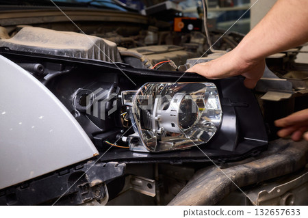 Careful precision is essential when installing a car headlight assembly for optimal performance 132657633