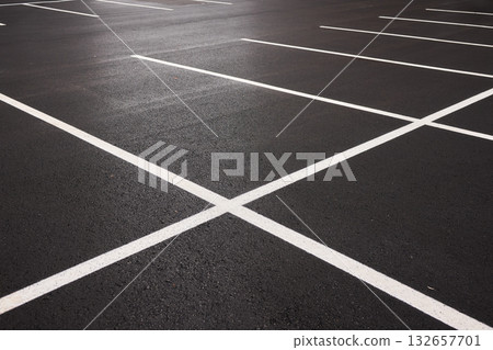 Reflective wet asphalt grid, Urban nighttime scene with textured asphalt and reflections, Cityscape at night showing glossy wet road surfaces and geometric line 132657701