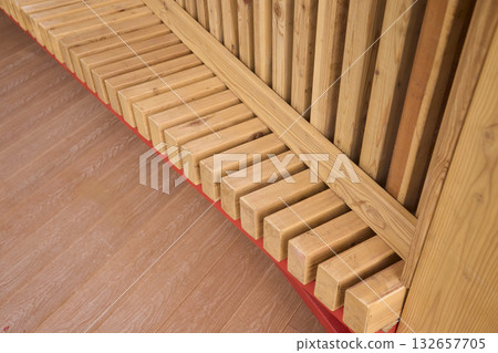 Wooden bench outdoors, Outdoor wooden bench with metal accents, Comfortable timber seating on urban plaza, Charming outdoor bench featuring red supports and warm wooden Wooden bench outdoors, Outdoor wooden bench with metal accents, Comfortable timber seating on urban plaza, Charming outdoor bench featuring red supports and warm wooden 132657705