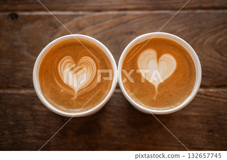 Couple cups of cappuccino coffee on wooden table. A cappuccino is the perfect balance of espresso, steamed milk and foam. 132657745