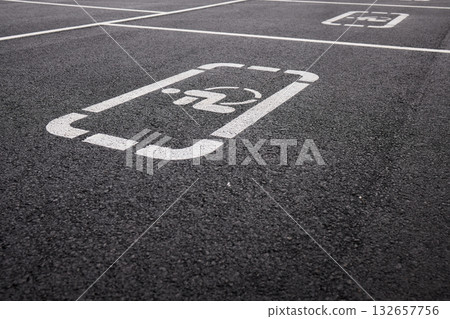 car parking space on asphalt, white worn markings, textured pavement, Handicap sign represents accessibility, inclusivity, equal rights, and consideration for individuals with disabilities 132657756