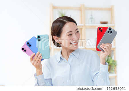 A woman with multiple smartphones 132658051