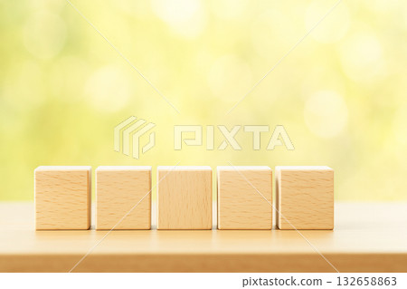 Five wooden blocks lined up and fresh green background material. Space for text. Healthcare. 132658863