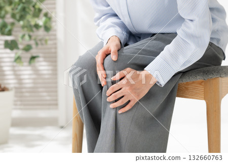 Woman holding her knees Woman holding her knees 132660763