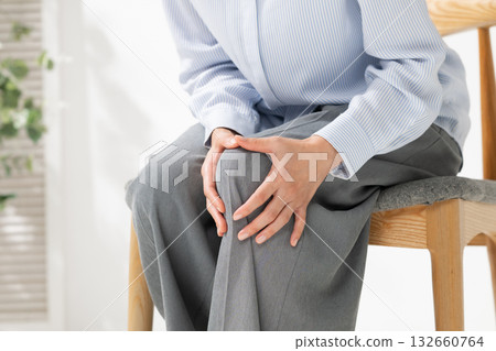 Woman holding her knees Woman holding her knees 132660764