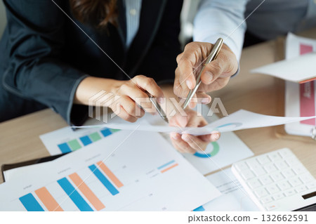 Business Collaboration and Financial Analysis. Professionals reviewing financial reports and charts together. Business Collaboration and Financial Analysis. Professionals reviewing financial reports and charts together. 132662591