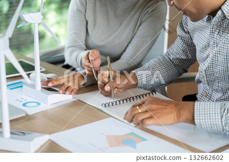 Sustainable Planning. Team collaborating on renewable energy project with charts. 132662602