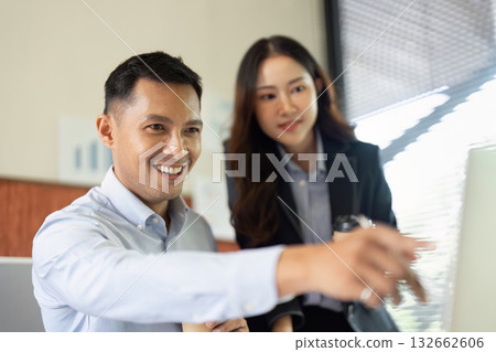 Collaborative Work in the Office. A man and woman share ideas while reviewing a project on a computer. 132662606