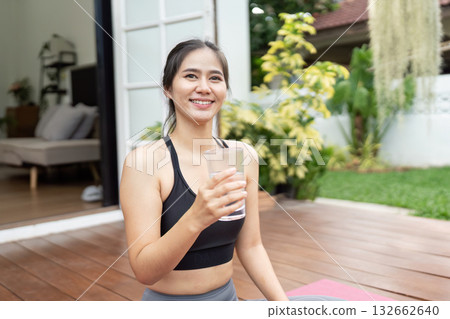 Healthy Lifestyle and Hydration. Young woman enjoying a drink of water after her fitness routine outdoors. Healthy Lifestyle and Hydration. Young woman enjoying a drink of water after her fitness routine outdoors. 132662640