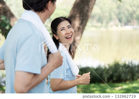 Wellness and Senior Fitness. Seniors enjoying a joyful jog by the lake, promoting health and happiness. 132662719