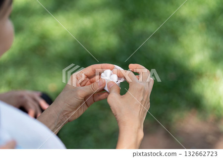 Wellness and Senior Mindfulness. A senior engaging in a mindful moment with a flower. 132662723